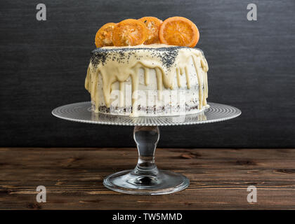 Les graines de pavot cake au chocolat blanc et orange caramélisé sur bois rustique Banque D'Images