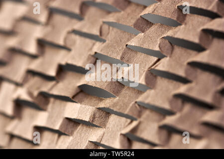 Close-up of a surface en carton avec une série de rainures qui forment un motif aidé par le soleil qui forme des ombres marquées Banque D'Images