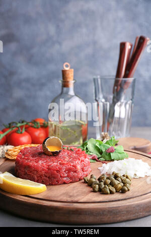 Délicieux steak tartare de vitellus dans la coquille sur planche de bois Banque D'Images