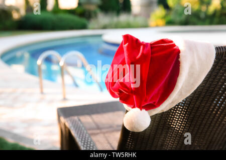 Santa hat sur une chaise longue près de la piscine de l'hôtel. Concept de Noël Banque D'Images