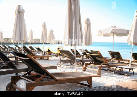 Chaises vides avec patio parasols sur la plage Banque D'Images