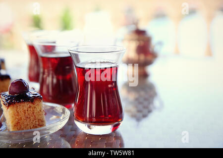 Du thé turc traditionnel dans des verres avec des desserts sur la table Banque D'Images