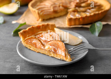 Plaque avec morceau de tarte aux poires savoureuses sur table Banque D'Images