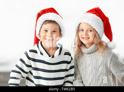 Petits enfants à Santa hats sur fond clair Banque D'Images