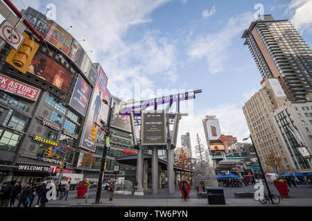 TORONTO, ONTARIO - Le 14 novembre 2018 : La rue Yonge Dundas Square, avec les gens et les voitures traversant sur un trottoir, entouré de gratte-ciel, des centres commerciaux, magasins et s Banque D'Images