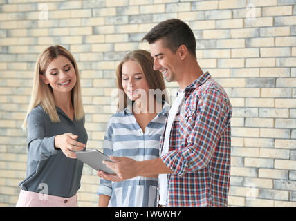 Courtier immobilier et clients with tablet computer in new flat Banque D'Images