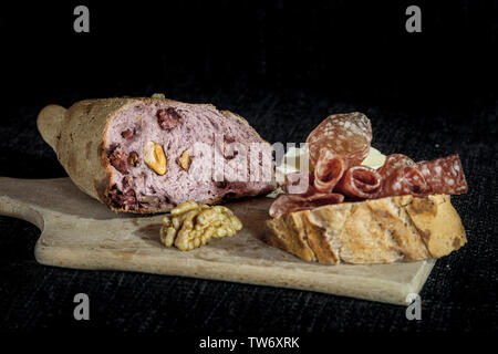 De pain au levain français, appelé aussi Pain de campagne, farcies de viande et de noix sur un fond noir avec une tranche de pain avec saucisse sèche ( Banque D'Images