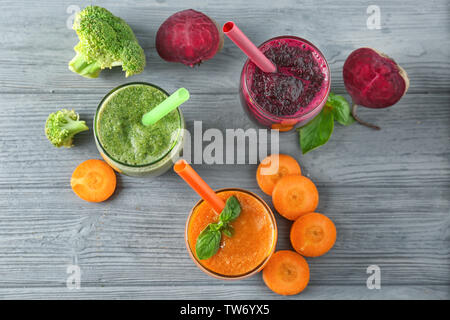 Lunettes avec différents smoothies de légumes sur fond de bois Banque D'Images