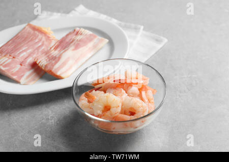 La composition avec crevettes crues et du bacon sur la table Banque D'Images