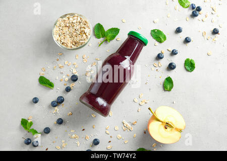 La composition avec l'açaï jus en bouteille de verre sur la table Banque D'Images