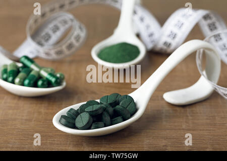 Les comprimés de spiruline avec une cuillère sur la table Banque D'Images