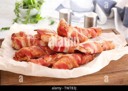 Nuggets de poulet enveloppé de bacon sur planche de bois Banque D'Images