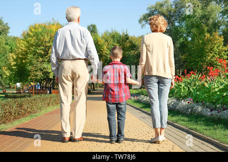 Couple de personnes âgées avec petit-fils walking in park Banque D'Images