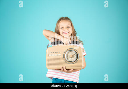 Petite fille avec radio contre l'arrière-plan couleur Banque D'Images