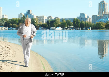 Homme mûr en marche près de la rivière Banque D'Images