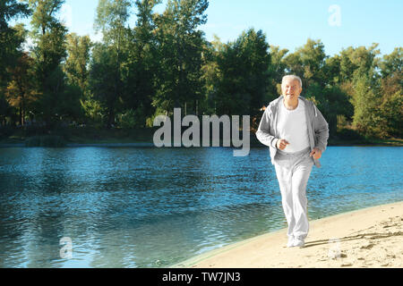 Homme mûr en marche près de la rivière Banque D'Images