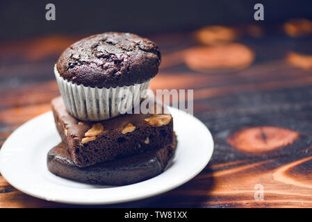 Cupcake chocolat sur le Brownie au chocolat blanc sur fond sombre avec palte Banque D'Images