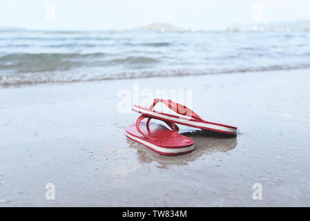 Tongs sur la plage avec des vagues plage de sable de mer à l'océan Banque D'Images