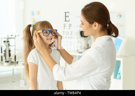 Adorable petit enfant essayant sur de nouvelles lunettes ophtalmologue dans