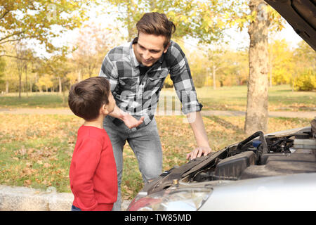 Jeune père avec cute boy la réparation de voiture, à l'extérieur Banque D'Images