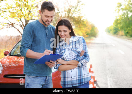 Jeune femme et d'instructeur de conduite debout près de voiture Banque D'Images