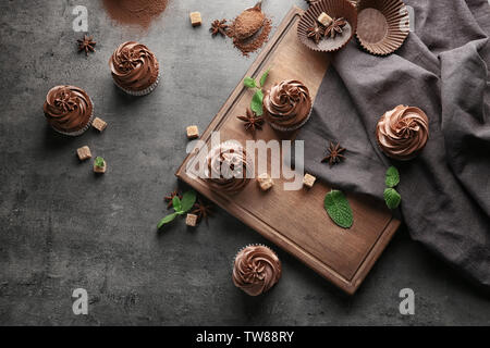 La composition avec de délicieux petits gâteaux au chocolat sur fond sombre Banque D'Images