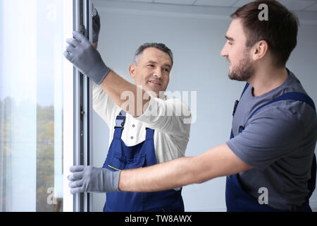 Travailleur de la construction avec l'installation dans la fenêtre stagiaire house Banque D'Images