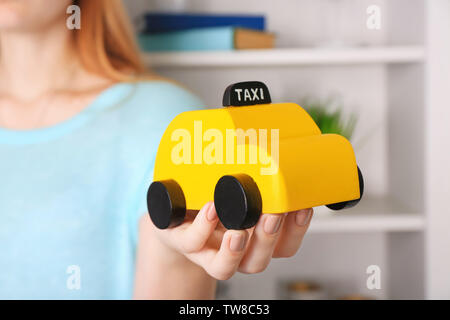 Woman holding toy jaune taxi cab, à l'intérieur Banque D'Images