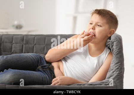 L'excès de boy eating donut à la maison Banque D'Images