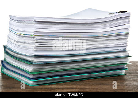 Pile de documents sur la table contre fond blanc Banque D'Images