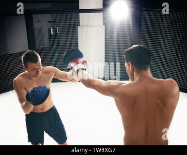 Les jeunes en formation boxer de sport avec coach personnel Banque D'Images