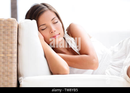 Sleeping Beauty woman on sofa - pretty asian young mixed race détendue modèle puissance dormir ou faire une sieste, vêtu de blanc robe d'été. Banque D'Images