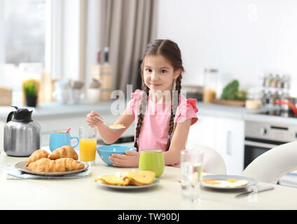 Petite fille de prendre le petit déjeuner dans la cuisine Banque D'Images