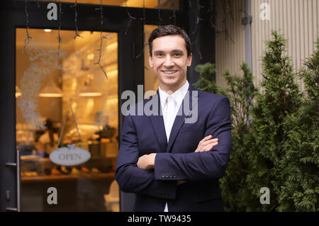 Jeune homme debout près de magasin. Propriétaire de petite entreprise portrait Banque D'Images