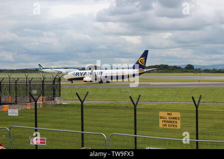 Les familles en visite dans la piste de l'aéroport de Manchester parc visiteur regardant l'avion aller et venir Banque D'Images