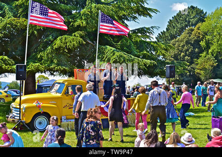 'La liberté Sisters' trio vocal effectuant de succès américains des années 20 s-30s à l'arrière de la dépanneuse GMC classique au Classic Car Show.Les gens danser/ regarder. Banque D'Images