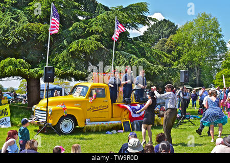 'La liberté Sisters' trio vocal effectuant de succès américains des années 20 s-30s à l'arrière de la dépanneuse GMC classique au Classic Car Show.Les gens danser/ regarder. Banque D'Images