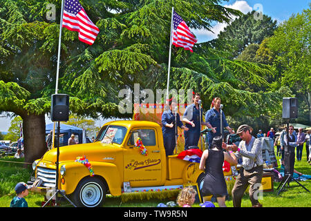 'La liberté Sisters' trio vocal effectuant de succès américains des années 20 s-30s à l'arrière de la dépanneuse GMC classique au Classic Car Show.Les gens danser/ regarder Banque D'Images