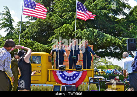 'La liberté Sisters' trio vocal effectuant de succès américains des années 20 s-30s à l'arrière de la dépanneuse GMC classique au Classic Car Show.Les gens danser/ regarder. Banque D'Images