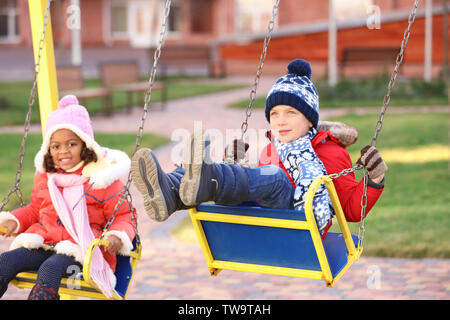 Cute little kids sur l'aire de jeux. Adoption de l'enfant Banque D'Images