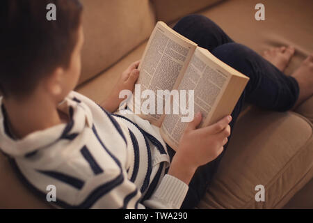 Kiev, UKRAINE - le 03 janvier 2018 : little boy reading Bible sur canapé Banque D'Images