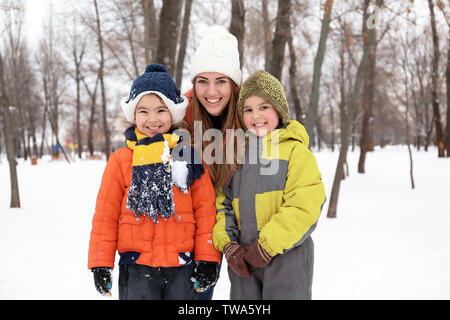 Femme heureuse avec des fils dans le parc de vacances d'hiver sur neige Banque D'Images