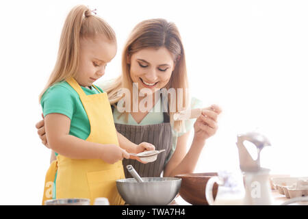 Mère fille avec sasser la farine dans la cuisine Banque D'Images