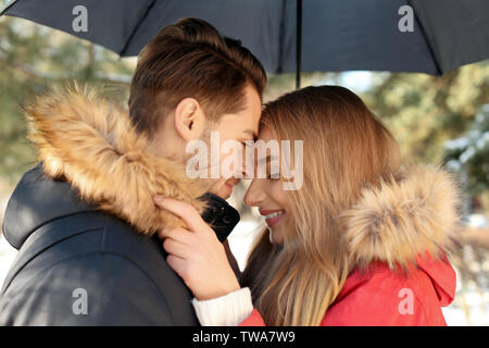 Jeune couple romantique avec parapluie dans park Banque D'Images