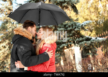 Jeune couple romantique avec parapluie dans park Banque D'Images