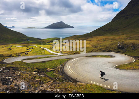 Jeunes patineurs équitation une planche à roulettes à travers le paysage magnifique des îles Féroé Banque D'Images