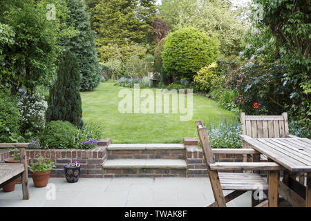 Meubles de patio avec jardin et pelouse dans un jardin typiquement anglais à Londres, Royaume-Uni Banque D'Images