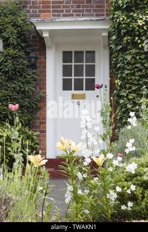 La moitié-vitrage porte en bois d'une maison d'époque à Londres avec un joli jardin de fleurs Banque D'Images