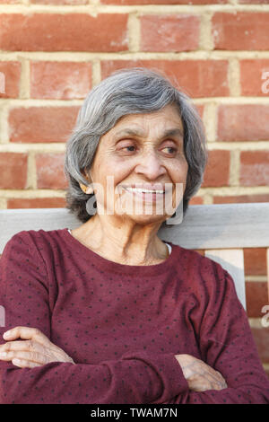 Personnes âgées vieux Indiens asiatiques femme assise avec un visage souriant, représentant de la santé et du bonheur dans la vieillesse et retraite Banque D'Images