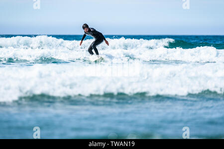 Guy surfeur surf avec surf sur des vagues dans l'océan Atlantique. L'homme en combinaison de surf est actif le surf les vagues de froid de l'océan atlantique en Galice, S Banque D'Images